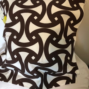 May include: White fabric with a brown geometric pattern of interlocking circles and squares.