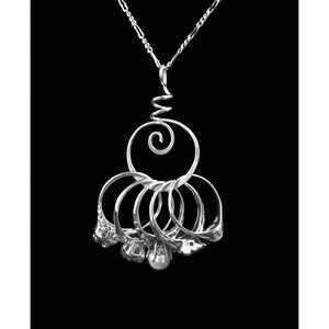 May include: A silver necklace with a spiral pendant and multiple rings hanging from it. The rings are arranged in a cluster and have a textured surface.