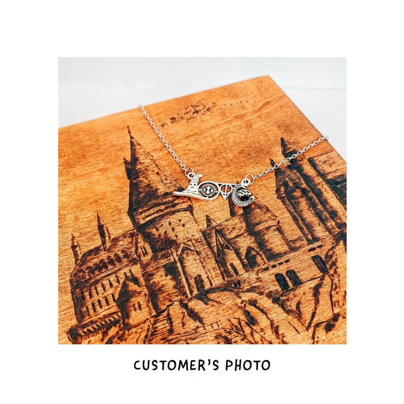 May include: A silver necklace with a charm that says "Love" with a Hogwarts castle design in the background.