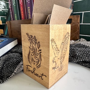 May include: A wooden box with a fire and a bird design, the text "Fireheart" is engraved on the front of the box.