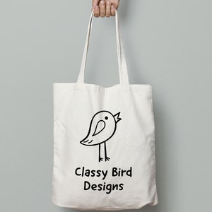 May include: White canvas tote bag with black handles and a black and white illustration of a bird with the text "Classy Bird Designs" printed on the front.