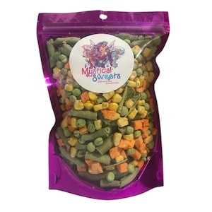 May include: A clear, purple-edged bag filled with a colorful mix of vegetables, including green beans, peas, corn, and carrots. A round sticker with the text "Mystical Sweets" and a fairy graphic is on the front.