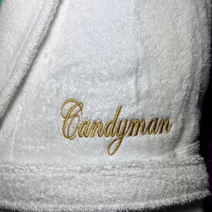May include: White bathrobe with the name "Candyman" embroidered in gold thread.