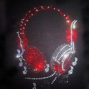 May include: Red and clear rhinestone design of headphones with musical notes on a black fabric background. The design measures 18 by 25 centimeters.