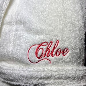 May include: White bathrobe with red embroidered lettering that says "Chloe".