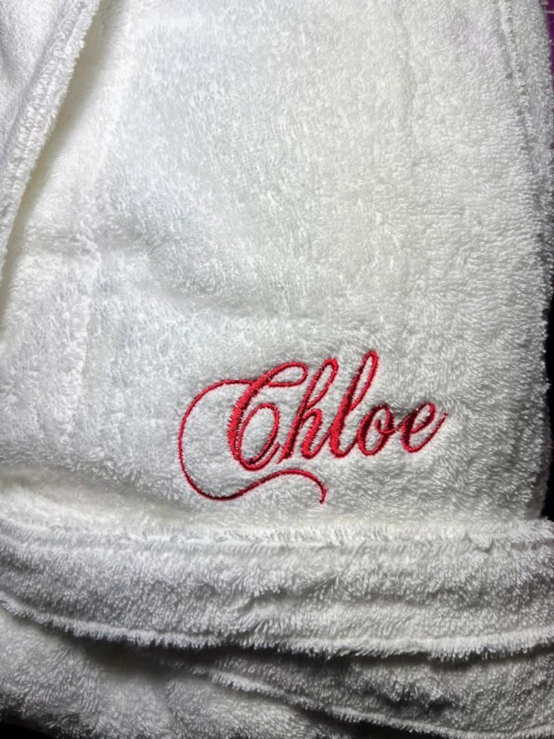May include: White bathrobe with red embroidered lettering that says "Chloe".