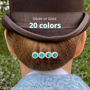 May include: A silver or gold hair comb with four turquoise rhinestones. The comb is in a woman's hair. The text "20 colors" is visible in the image.