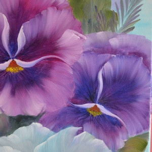 May include: A close-up of a painting of purple and blue pansies with white accents. The pansies are in focus, while the background is blurred.