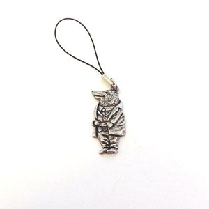 May include: A silver charm featuring a cartoon animal in a suit, holding a cane. The charm is attached to a black string.