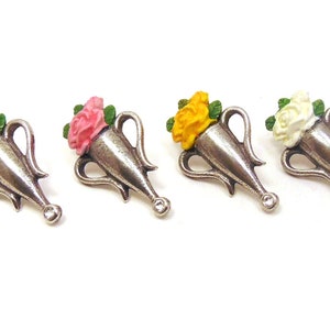 May include: Four silver-toned flower vase charms with different colored flowers. The vases are in the shape of a traditional urn with two handles. The flowers are red, pink, yellow, and white.