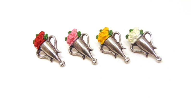 May include: Four silver-toned flower vase charms with different colored flowers. The vases are in the shape of a traditional urn with two handles. The flowers are red, pink, yellow, and white.