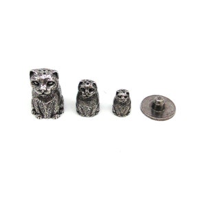 May include: Set of four silver cat-shaped thimbles, one large, one medium, one small, and one flat disc.