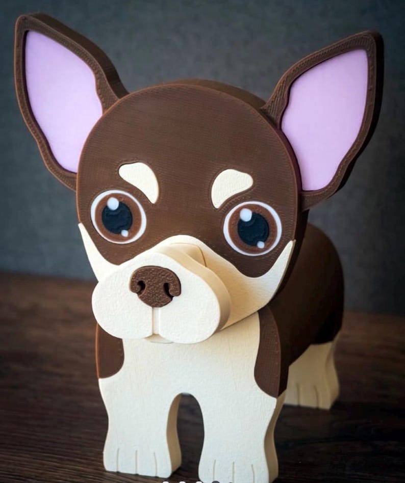 May include: A wooden chihuahua dog figurine with a brown body, white face, and large, expressive eyes. The dog has pink inner ears and is standing on a wooden surface. The figurine is a decorative item.