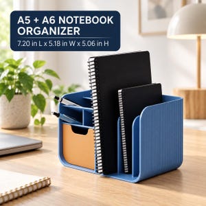 May include: A blue desk organizer with a ribbed texture, featuring a small orange drawer, two vertical slots holding black spiral-bound A5 and A6 notebooks, and two small compartments for pens. Dimensions are 7.20 in L x 5.18 in W x 5.06 in H.