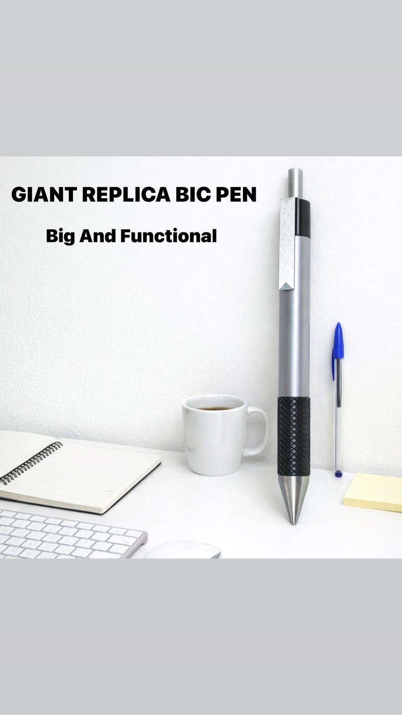 K&ouml;nnte beinhalten: Ein riesiger BIC-Stift-Nachbau mit silbernem Geh&auml;use, schwarzer, strukturierter Griffzone und silbernem Clip, platziert neben einem blauen Standard-Kugelschreiber. Der Text GIANT REPLICA BIC PEN Big And Functional ist oben links zu sehen.
