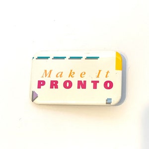 Puede incluir: Un botón rectangular con las palabras "Make It PRONTO" en naranja y rosa. El botón tiene un fondo blanco con detalles turquesa y amarillo. También se ven un pequeño triángulo morado y un cuadrado gris.