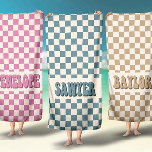 May include: Three checkered beach towels with names "PENELOPE", "SANYER", and "BAYLOR" written in a retro font.