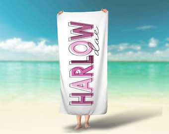 Puede incluir: Una toalla de playa blanca con la palabra "HARLOW" impresa en letras rosadas y negras con contorno. La palabra "love" está escrita en cursiva debajo de la palabra "HARLOW".