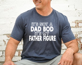 May include: A navy blue t-shirt with white text that reads "It's not a dad bod it's my father figure."
