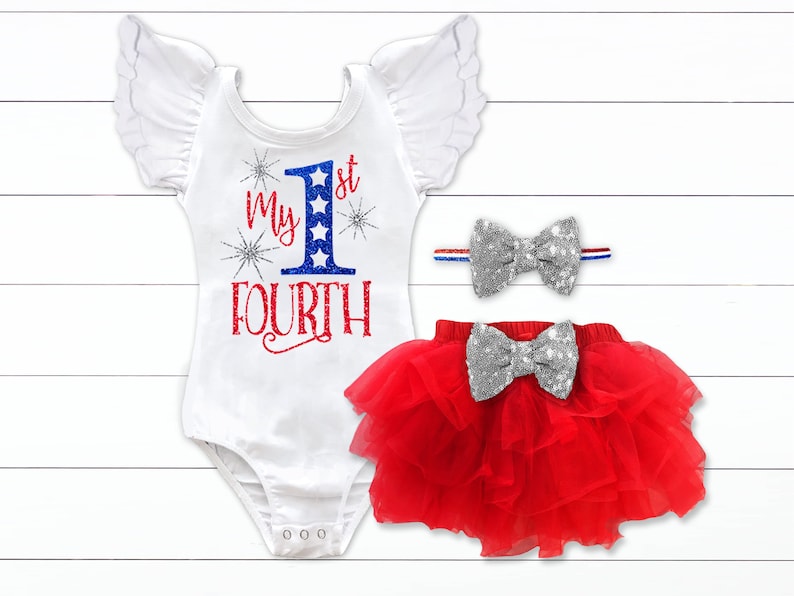 Puede incluir: Un body blanco con detalles de purpurina roja, blanca y azul. El body tiene el texto "My 1st Fourth" en la parte delantera. Se incluye una falda de tul roja con un lazo de purpurina plateada. Tambi&eacute;n se incluye una diadema con un lazo de purpurina plateada y rayas rojas, blancas y azules.