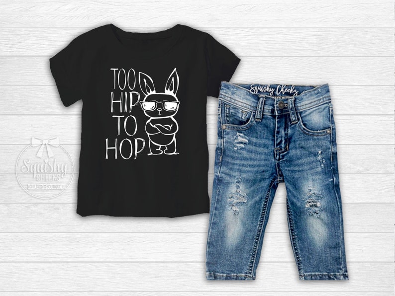 Black boy easter shirt adorned with a funny graphic featuring a bunny wearing sunglasses and text saying too hip to hop with distressed denim jeans