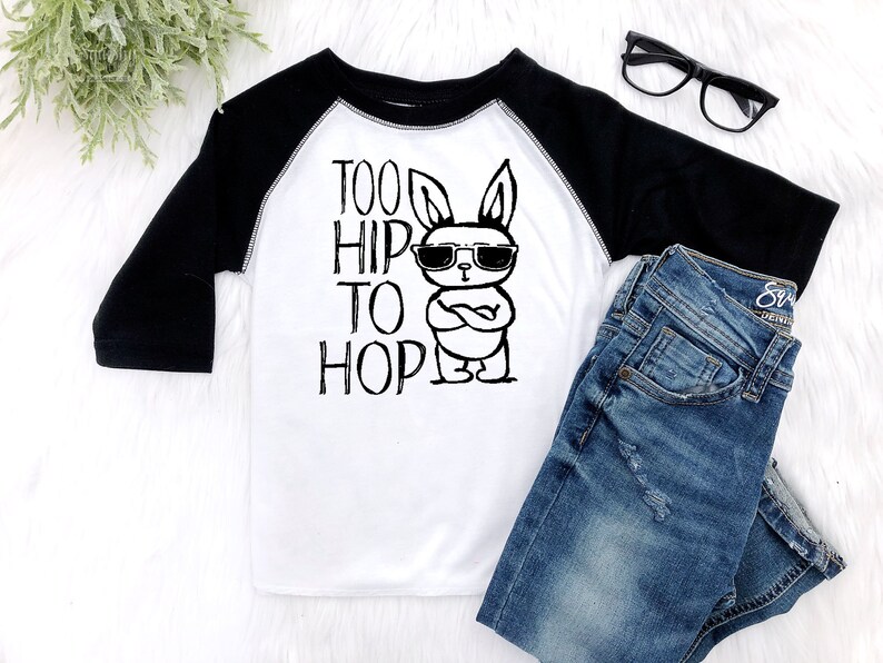 Black and white raglan boy easter shirt adorned with a funny graphic featuring a bunny wearing sunglasses and text saying too hip to hop