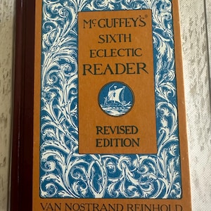 May include: A vintage book titled "McGuffey's Sixth Eclectic Reader, Revised Edition." The cover is a warm orange with blue and white decorative scrollwork. The spine is a deep burgundy, and the publisher is Van Nostrand Reinhold.