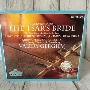 May include: A blue and white CD case with a picture of a necklace and a locket on a red-stained surface. The text on the case reads "RIMSKY-KORSAKOV THE TSAR'S BRIDE Die Zarenbraut La fiancée du Tsar SHAGUCH HVOROSTOVSKY AKIMOV BORODINA KIROV OPERA & ORCHESTRA Mariinsky Theatre, St Petersburg VALERY GERGIEV KIROV PHILIPS".