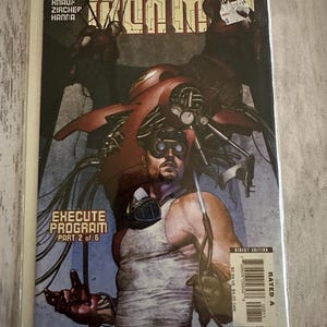 May include: Comic book cover featuring Iron Man in a red and silver suit, with the text "The Invincible Iron Man" and "Execute Program Part 2 of 6" on the cover.