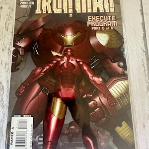 May include: A comic book cover for "The Invincible Iron Man" featuring a red and gold Iron Man suit in front of a larger, similar armored figure. The cover includes the text "EXECUTE PROGRAM PART 6 of 6" and the Marvel Comics logo.