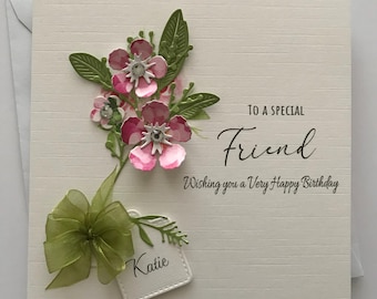 May include: A white card with a green bow and pink flowers. The card says "To a Special Friend Wishing you a Very Happy Birthday" and is signed "Katie".