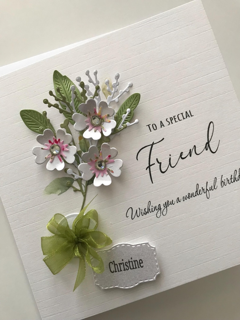 Może przedstawiać: Biała kartka z zieloną kokardką i kwiatowym wzorem. Na kartce napisano "To a special Friend Wishing you a wonderful birthday" i podpisano "Christine".