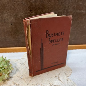 May include: A vintage brown book titled "Business Speller 4th Edition" by Peters.