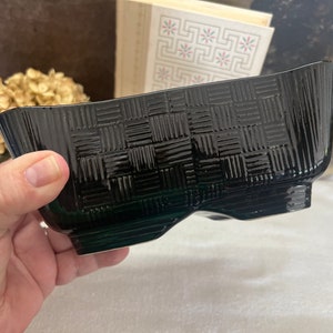 May include: A black ceramic planter with a woven pattern. The planter has a rectangular shape with rounded edges.