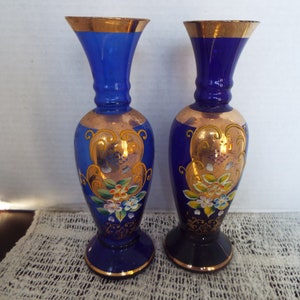 May include: Pair of cobalt blue glass vases with gold trim and painted floral designs.