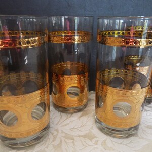 May include: Set of six clear glass highball glasses with gold and amber colored bands and a gold circle design.