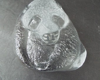 May include: A clear glass sculpture of a panda bear curled up in a sleeping position. The sculpture is detailed with textured fur and realistic facial features.