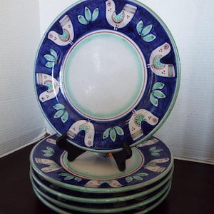 May include: Set of four blue and white ceramic dinner plates with a green and white bird design.