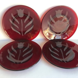 May include: Set of four red glass dessert plates with a white etched tulip design.