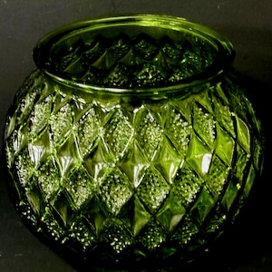 May include: A round, green glass bowl with a diamond pattern. The bowl has a wide opening and a textured surface. The color is a vibrant, translucent green, and the bowl appears to be made of thick glass.