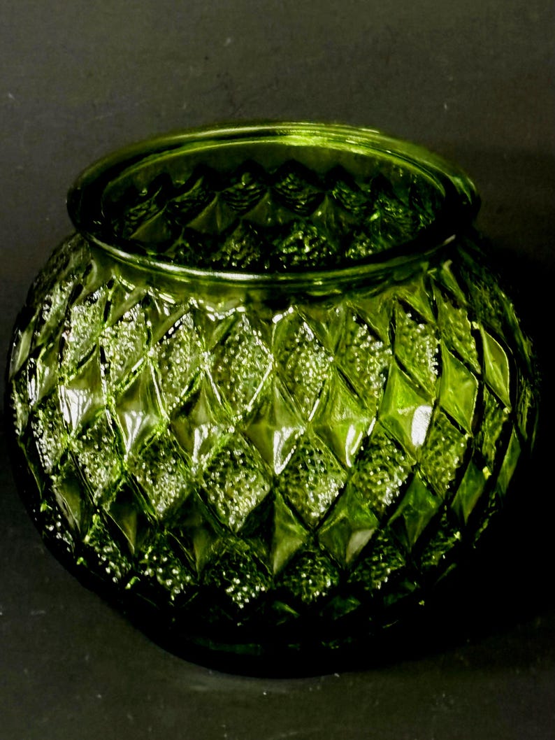 May include: A round, green glass bowl with a diamond pattern. The bowl has a wide opening and a textured surface. The color is a vibrant, translucent green, and the bowl appears to be made of thick glass.