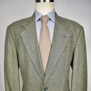 May include: A beige blazer with a black and white patterned design. The blazer has a single button closure and two pockets.