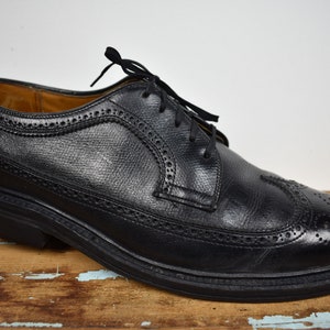 May include: Black leather lace-up dress shoes with a wingtip design.