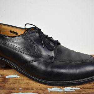Puede incluir: Zapatos de vestir negros de cuero con cordones y diseño de punta de ala.