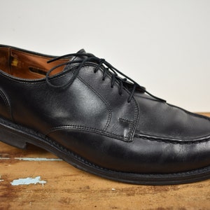 Puede incluir: Zapatos de vestir negros de cuero con cordones, punta puntiaguda y detalle cosido alrededor de la punta.
