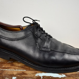 Peut inclure: Chaussures habillées en cuir noir à lacets, bout pointu et semelle épaisse.