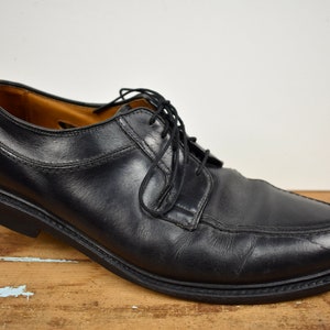 May include: Black leather lace-up dress shoes with a rounded toe.