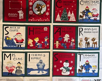 May include: A colorful fabric panel with a patchwork design featuring the characters from the Rudolph the Red-Nosed Reindeer television special. Each square features a letter of the alphabet and a scene from the show. The letters spell out "Rudolph, Christmas is... Santa, of course, Hermey, All the Misfits, Mrs. Claus, Cebergs & Bumble, Am the Snowman & Snowflakes & Songs, Teamwork, Rudolph & His Reindeer Friends".