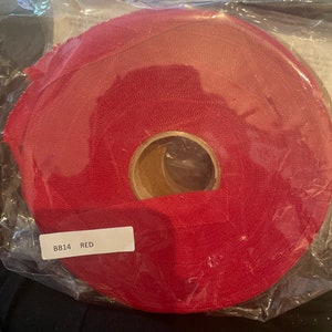 May include: A roll of red chenille trim, labeled "BB14 RED", with the text "blooming bias" and "Approx. 40 yards 100% Cotton" on the packaging.