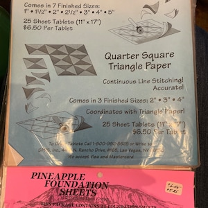 Puede incluir: Dos paquetes de suministros para acolchar. El paquete superior es azul y blanco y presenta papel triangular para acolchadores. El paquete inferior es rosa y blanco y presenta hojas de base de piña para acolchadores. Ambos paquetes presentan texto que describe el producto y sus características.